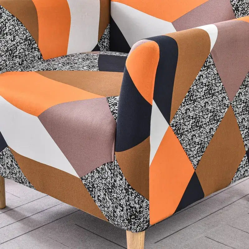 A modern accent chair covered with a bold geometric decorbites accent chair cover in orange black white and gray fabric