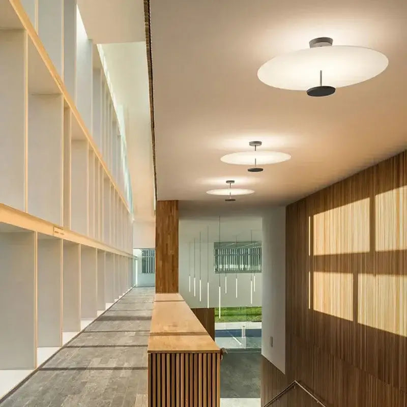 Modern white disc ceiling light with a sleek acrylic black round chandelier fixture for bedroom and salon lighting