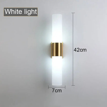 Decorbites™ wall lamp with frosted acrylic cylinder and gold metal bracket emitting soft white light for bedroom and study