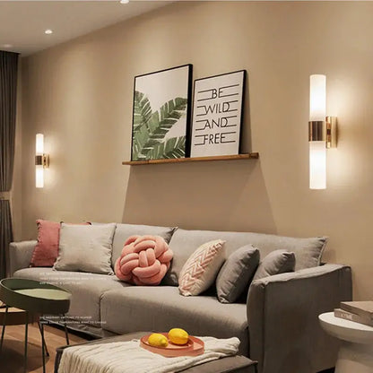 Modern gold-toned wall lamp featuring an acrylic cylinder wall design with a frosted glass shade for indoor lighting