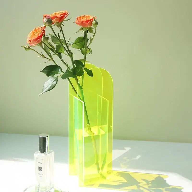 Vibrant lime-green translucent acrylic flower vase holding orange roses for home office decor by DecorBites™