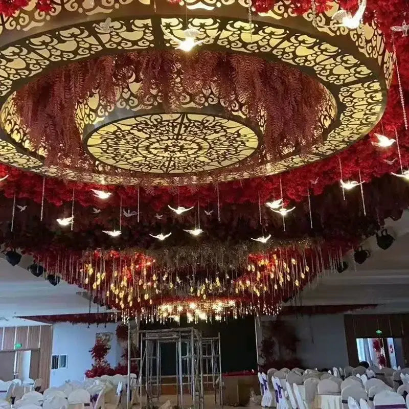 Ornate circular acrylic flying birds led lamp with warm lights and red floral garlands for wedding party décor