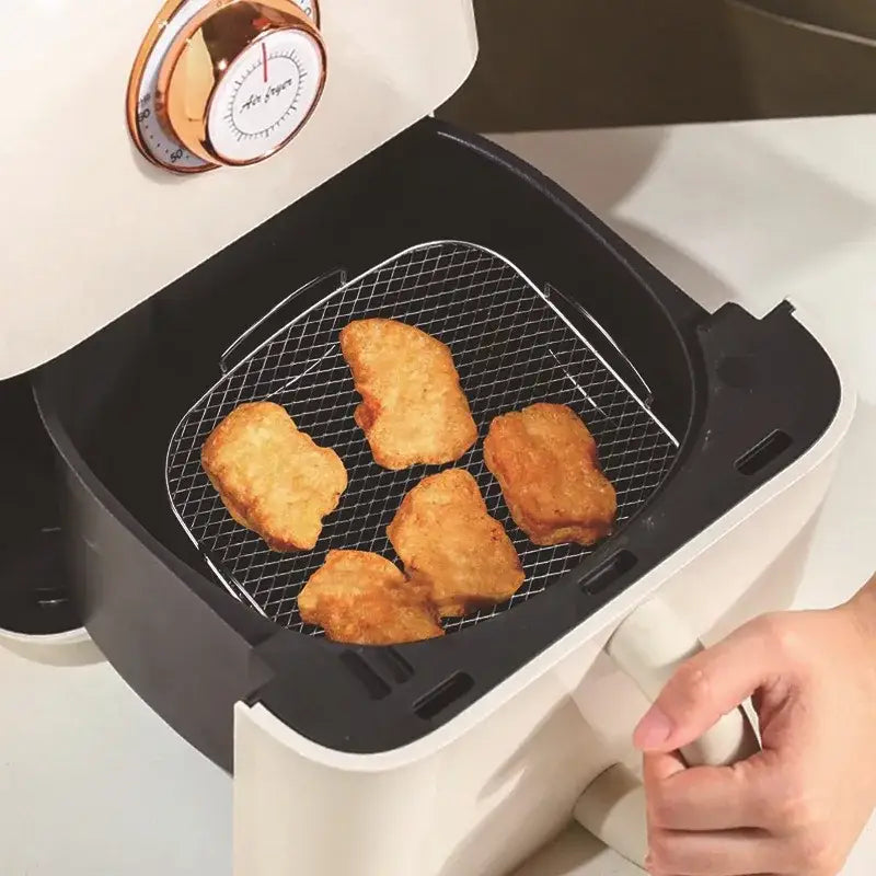 Decorbites air fryer with stainless steel dehydrator steel rack holding golden chicken nuggets in black and white design