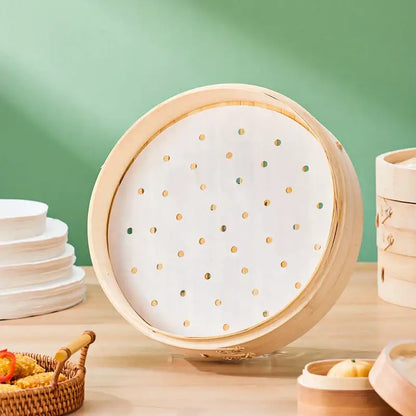 A round bamboo steamer basket with white perforated decorbites™ air fryer steamer papers featuring golden dots
