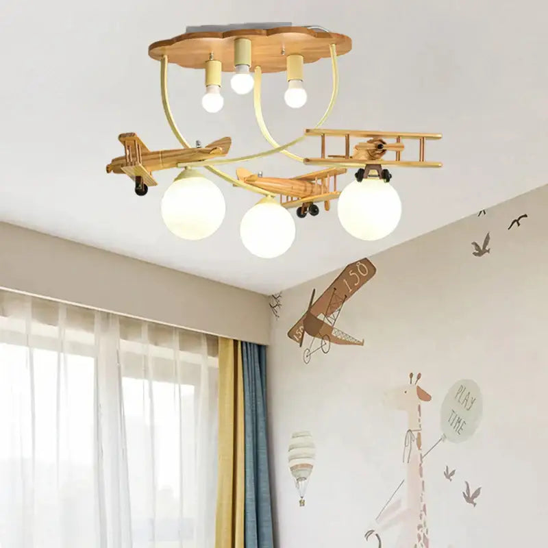 Decorbites™ wooden airplane chandelier light with three spherical bulbs and cloud-shaped top for nursery room ceiling