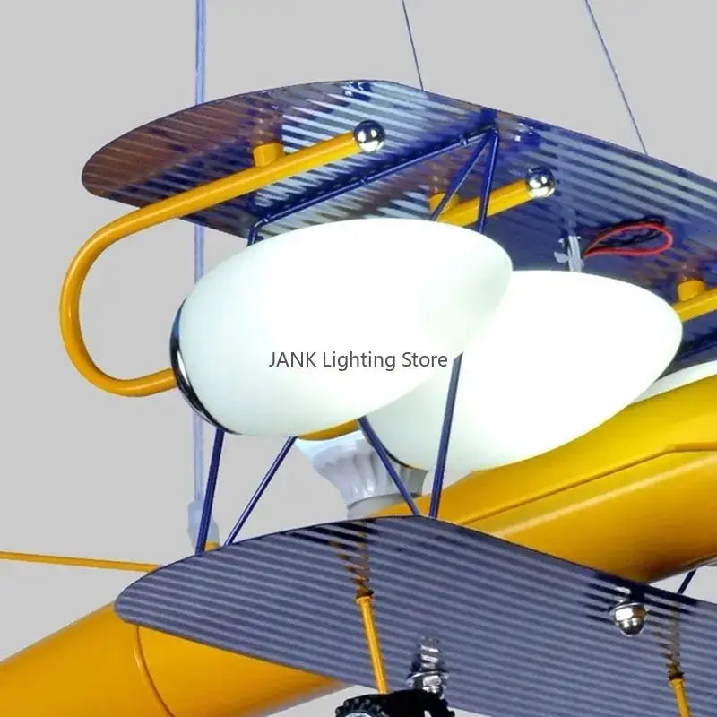 Decorbites airplane kids led chandelier featuring yellow blue biplane design with white oval glass shades for boys rooms