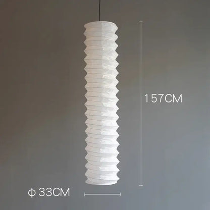 A tall white rice paper pendant light with a ribbed akari noguchi design hanging for home décor use