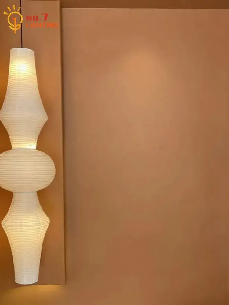 A modern off-white paper pendant light with a segmented sculptural design akari noguchi vintage style