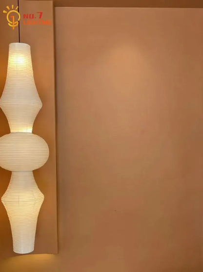 A modern off-white paper pendant light with a segmented sculptural design akari noguchi vintage style