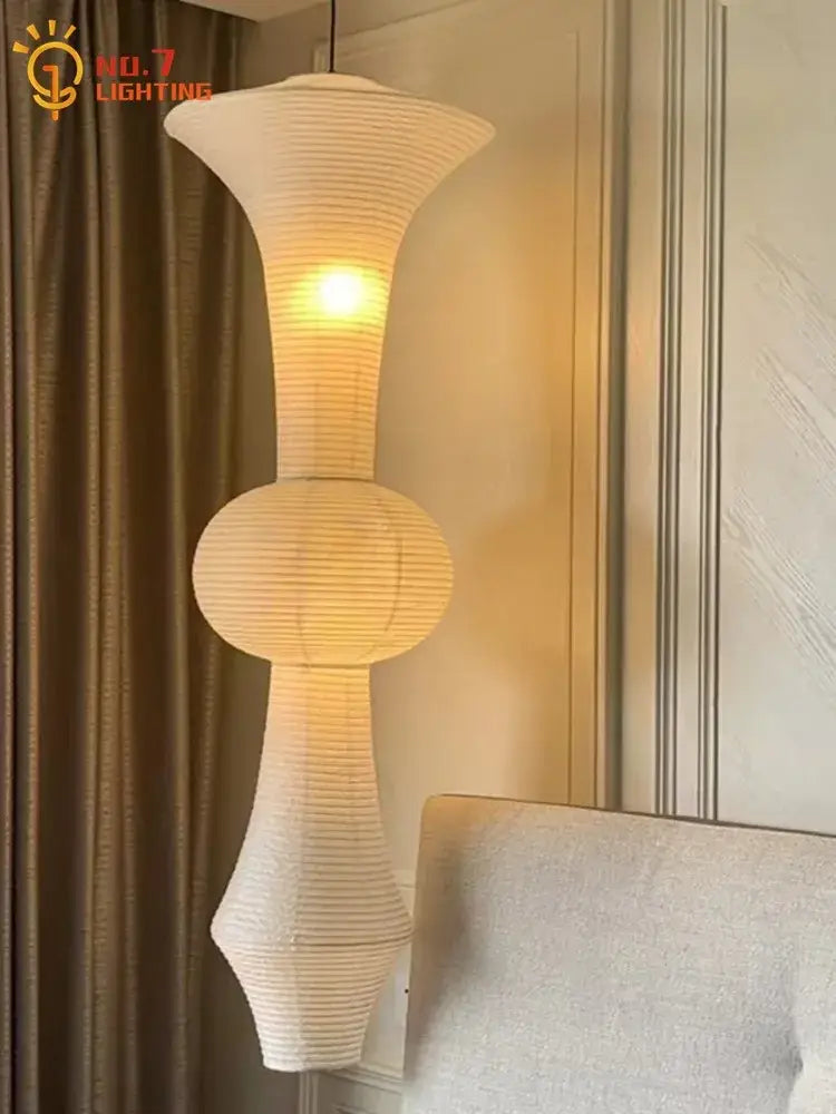 A cream-colored ribbed paper pendant light with a modern sculptural design from decorbites akari noguchi vintage series