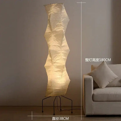 Cream-colored akari rice paper floor lamp with wavy design and black metal tripod base for vintage home decor