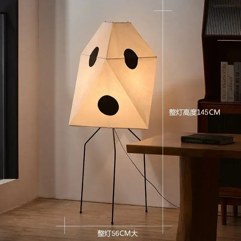 Beige geometric DecorBites™ Akari rice paper floor lamp with three black cutouts on a slender metal stand for home decor