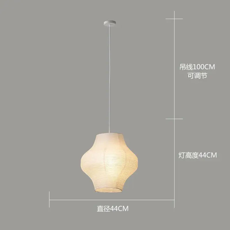 A warm glowing pendant lamp with off-white textured akari rice paper shade and slender white cord for living room