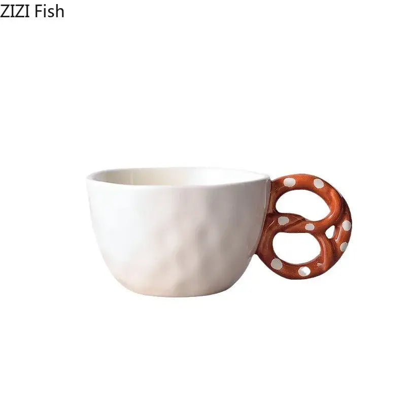 Cream-colored ceramic alkali water biscuit mug with orange pretzel-shaped handle and white polka dots