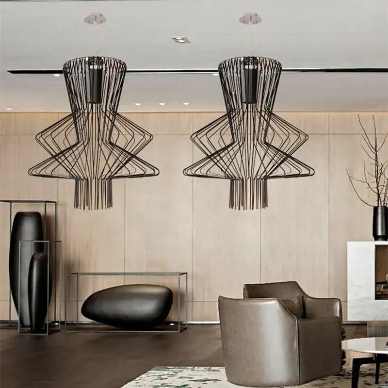 Two black wireframe geometric tiered allegro ritmico chandeliers hang from the ceiling in a vintage industrial style