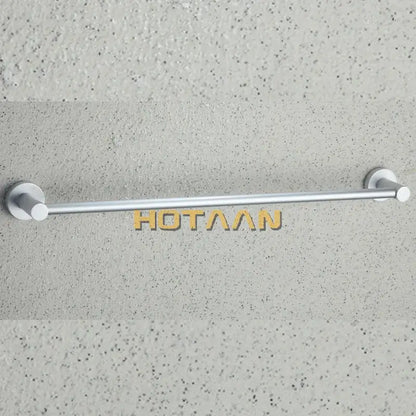 Silver-toned aluminium towel bar rail holder with sleek minimalist circular end caps mounted on textured wall
