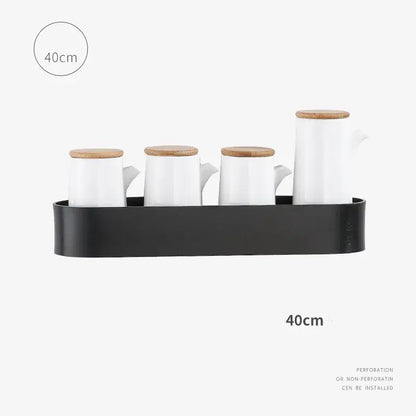 Set of four white ceramic pitchers with bamboo lids on a black tray on decorbites aluminum bathroom shelf with towel bar