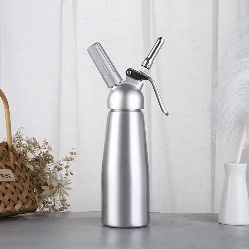 Silver metallic aluminum cream gun chantilly with textured handle and sleek cylindrical body for kitchen use