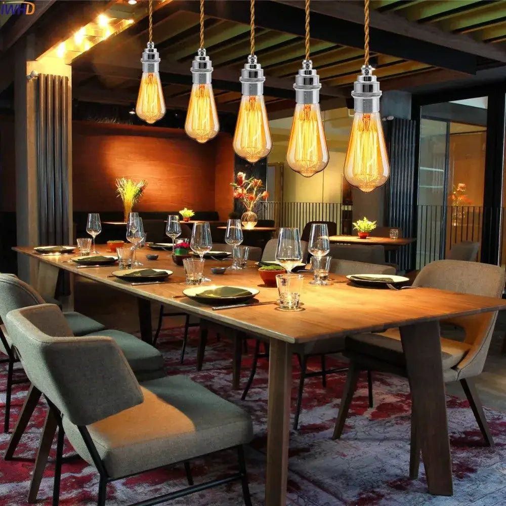 Five vintage-style edison bulb pendant lights with warm amber glass and chrome lamp base holders on twisted copper cords