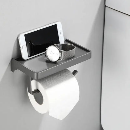 DecorBites aluminum gray wall-mounted tissue box rack with phone shelf holding a smartphone and watch