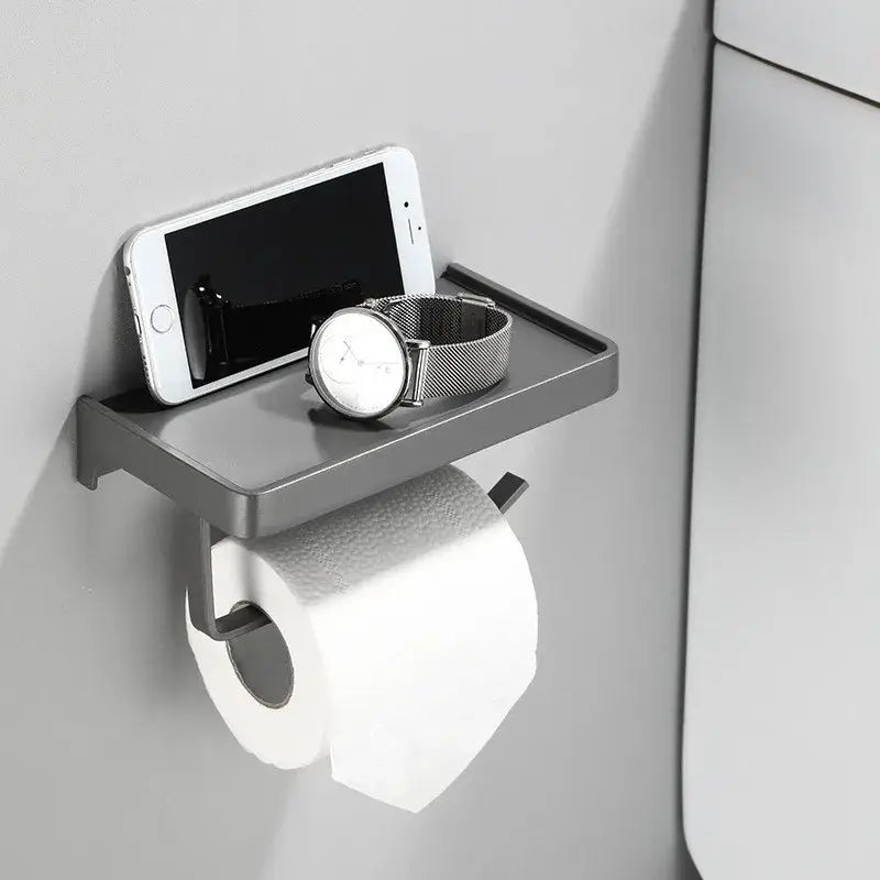 DecorBites aluminum gray wall-mounted tissue box rack with phone shelf holding a smartphone and watch