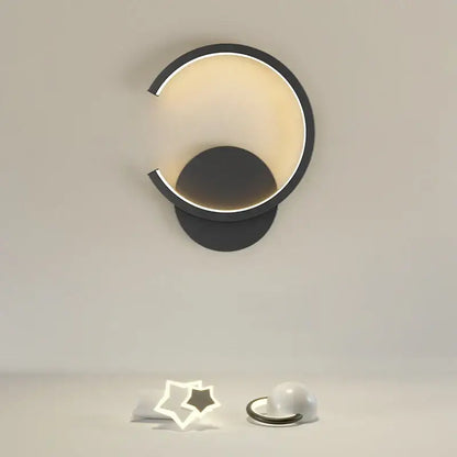 Modern black crescent-shaped aluminum led wall lamp with warm glowing interior light for bedroom and living room décor