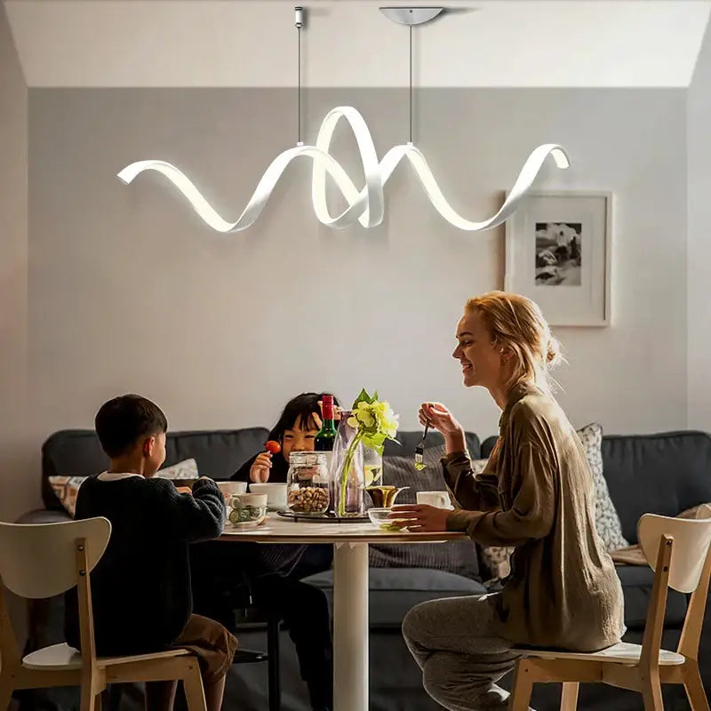 A modern white aluminum decorbites s-shaped pendant lamp with sleek wave design hanging above dining table
