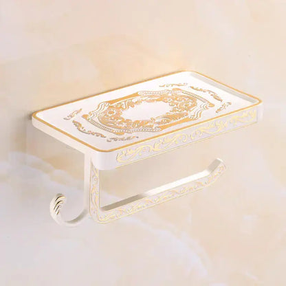 White and gold ornate aluminum toilet paper holder by DecorBites with decorative scrollwork and phone rack hook