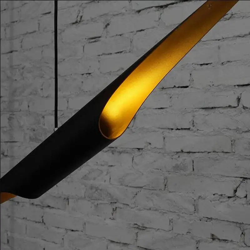 A sleek black decorbites aluminum tube chandelier with a glowing gold interior ideal for restaurant and bar lighting