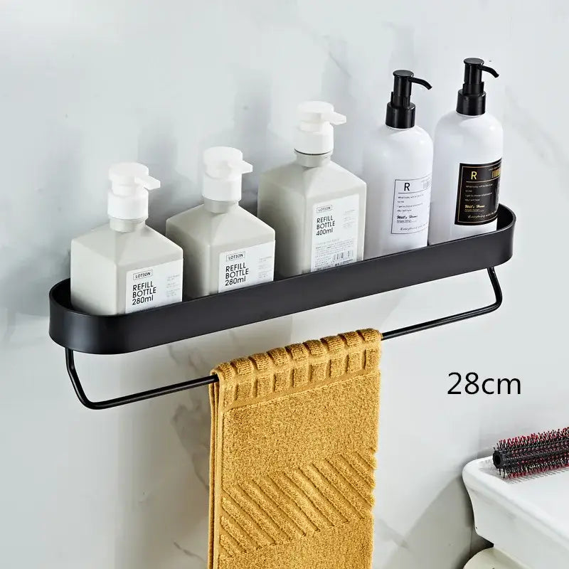 Black metal bathroom shelf with towel bar and corner storage shelf holding white pump bottles and mustard-yellow towel