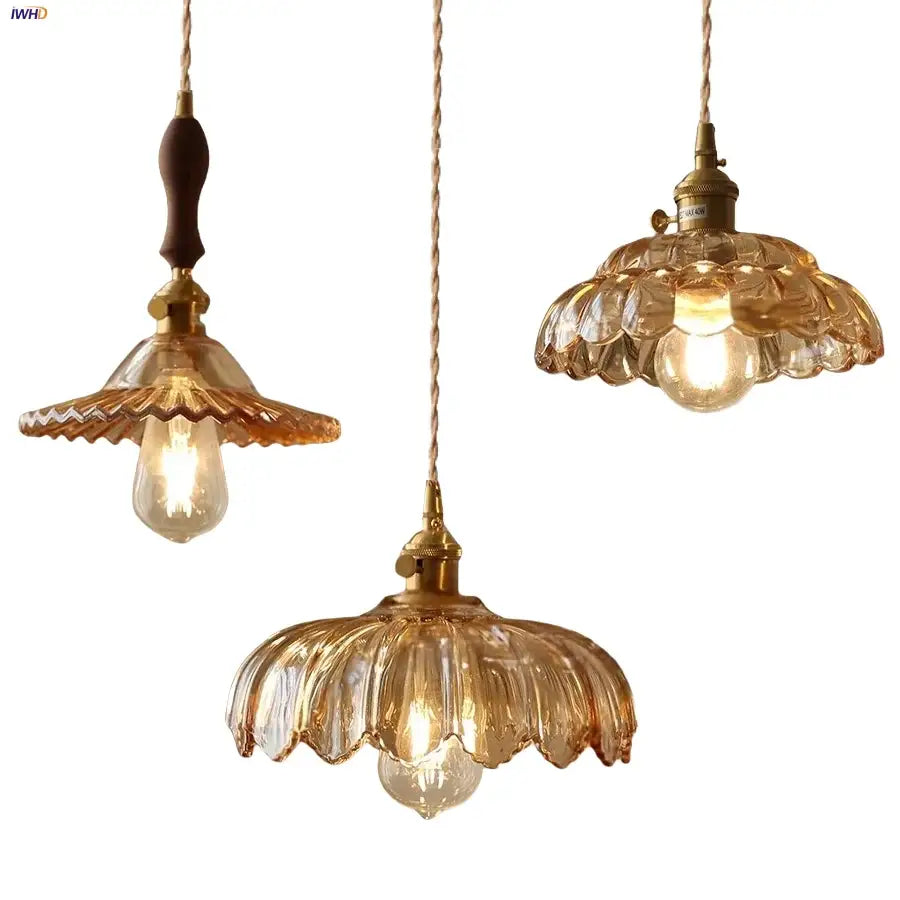 Three vintage-style pendant lights with amber flower glass led shades and brass fixtures in a modern nordic design