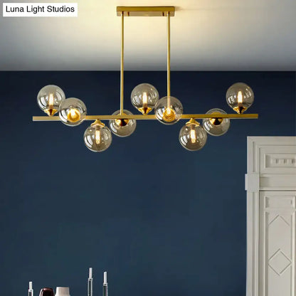 DecorBites™ modern gold hanging light with clear glass globe bulbs and amber glass accents for dining room island