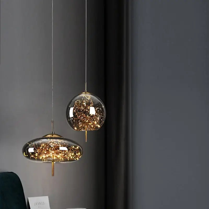 Decorbites amber glass chandelier featuring two modern glass pendant lights with golden fixtures and internal string lights