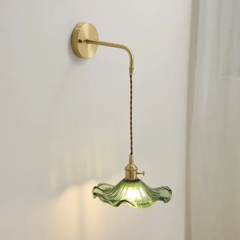 A delicate green glass wall sconce with fluted petal design and brass hardware by decorbites amber glass for indoor lighting