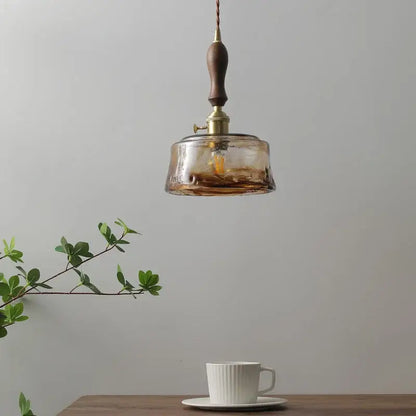 DecorBites amber glass pendant lamp with warm amber glass, brass fixture, and dark wood handle for modern interiors