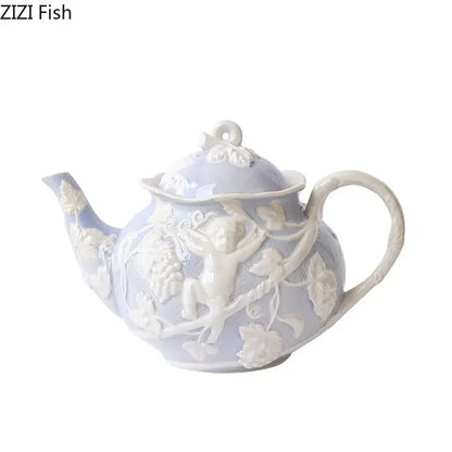 A delicate lavender ceramic teapot with intricate white angel figures relief of cherubs and grapevines from decorbites