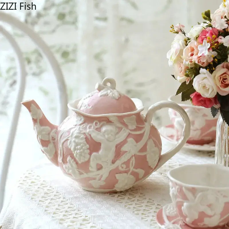 Pink ceramic teapot with white angel figures relief detailing of cherubs and vines from decorbites dining set
