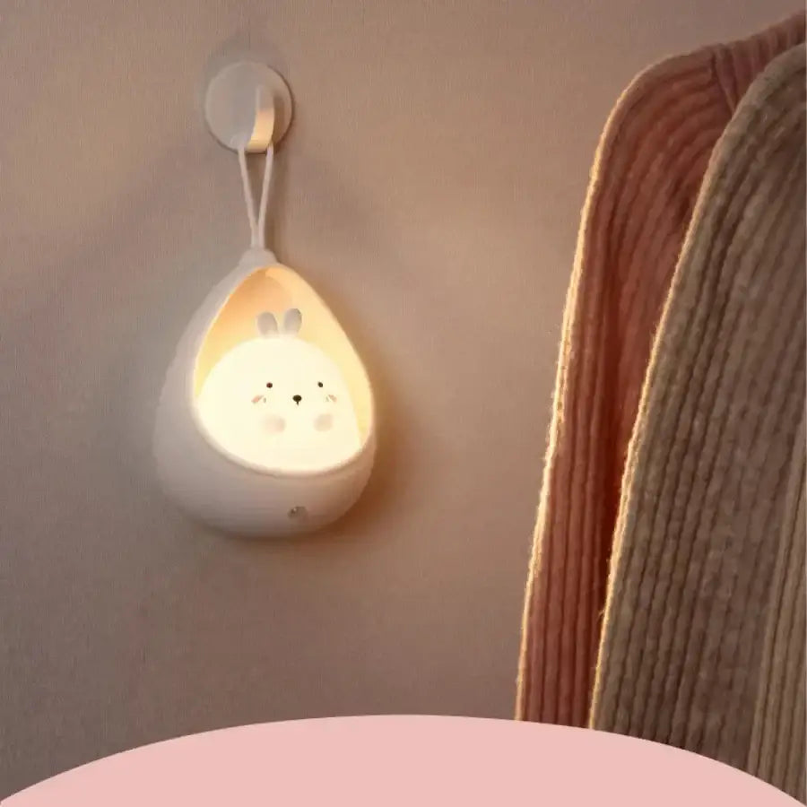 White ceramic wall-mounted animal night light with bunny face emitting warm glow usb rechargeable silicone led sensor control
