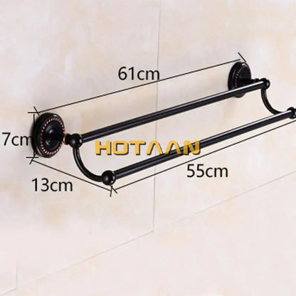 Black double towel bar by decorbites with ornate circular wall mounts and curved ends in antique brass finish