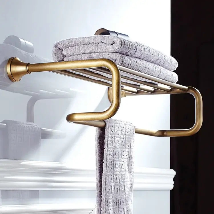 Decorbites antique brass bathroom accessory set featuring a brass finish towel rack with curved design and gray towels