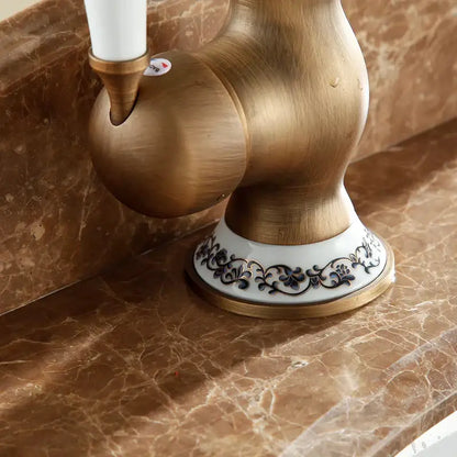 DecorBites™ antique brass bathroom sink faucet with single handle swivel spout and white ceramic base with floral patterns
