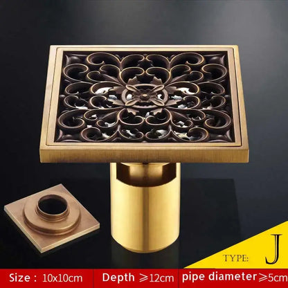 Square brass bathroom shower drain with ornate floral antique brass fish style cutout and matching cylindrical pipe
