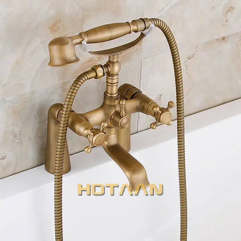 Antique brass shower head kit with classic bathtub faucet, two cross-handle knobs, and handheld shower head by decorbites