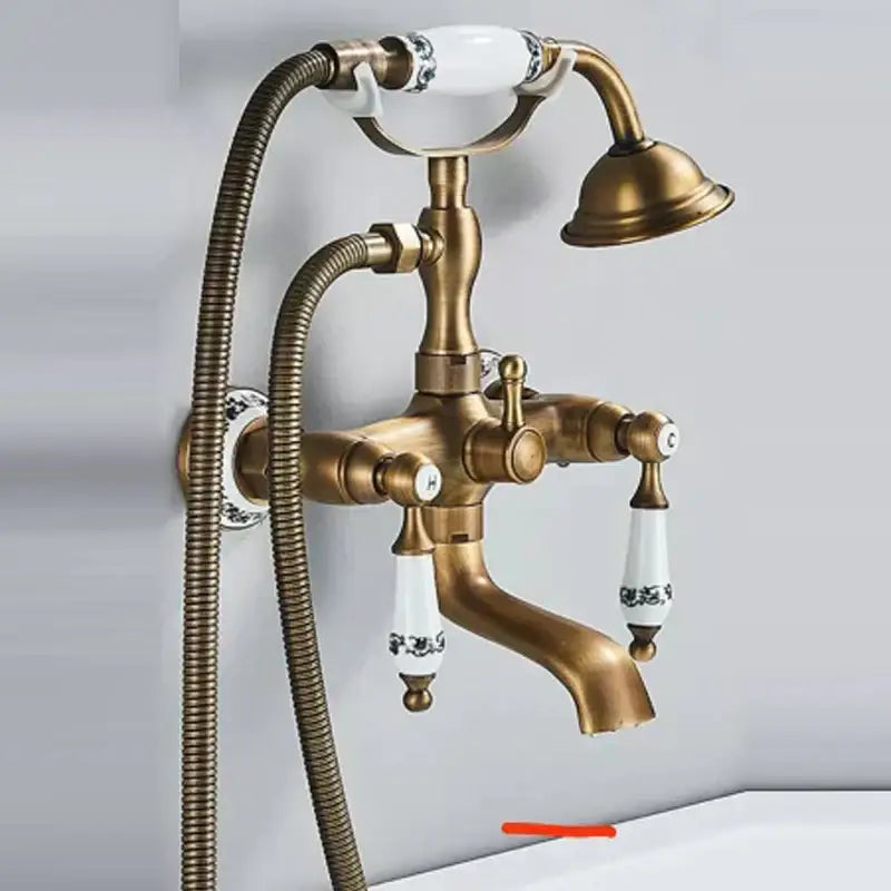 Antique brass shower head kit with white ceramic handles featuring black floral patterns and matching hand-held showerhead