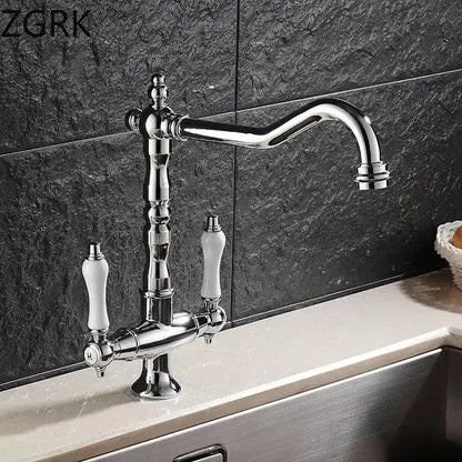 DecorBites™ antique brass kitchen faucet with chrome finish, dual white ceramic handles, ornate detailing, and 360° rotation
