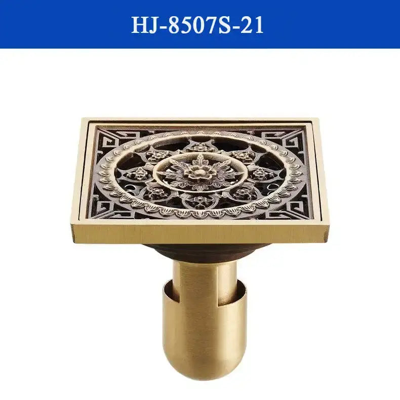 Brass shower drain cover with antique brass finish featuring intricate floral and geometric embossed design