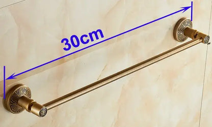 Antique brass double towel rack featuring ornate floral-patterned circular ends for wall mounted bathroom use