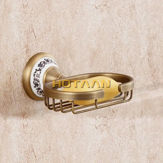Antique brass soap holder by decorbites featuring a white ceramic backplate with black floral patterns and a yellow soap bar