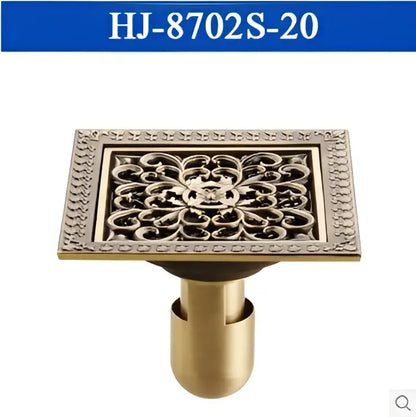 Brass-colored antique brass square floor drain with ornate floral pattern and decorative border for shower use