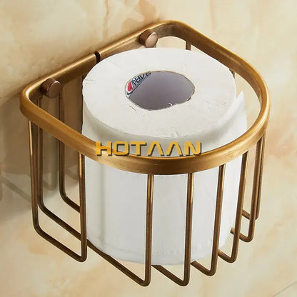 Brass-toned antique brass toilet paper holder with cylindrical wireframe design holding a white roll for wall mounting